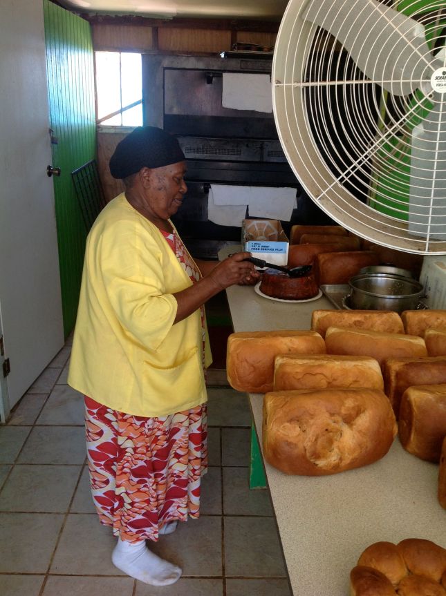 "Mom" drizzling a rum sauce over a large rum cake we purchased